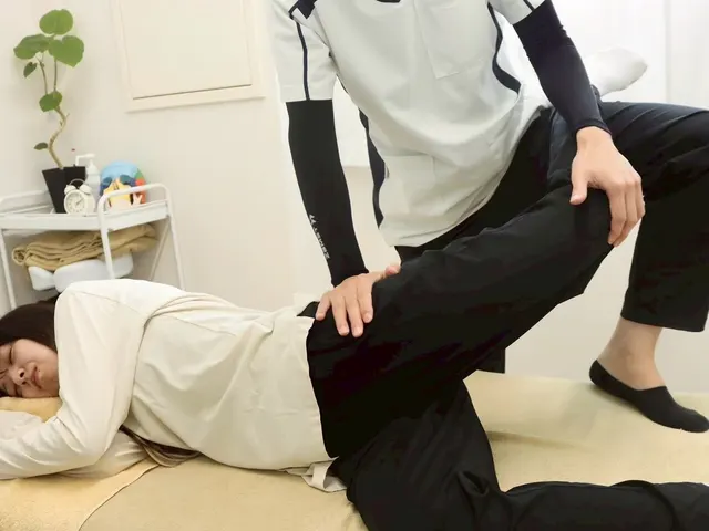 産後骨盤矯正の施術風景：横向きで骨盤・股関節まわりをやさしく調整する様子